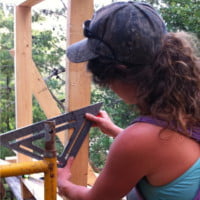 woman using a speed square to do carpentry