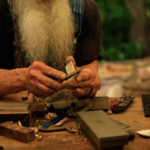 sharpening a knife with a table of sharpening stones laid out