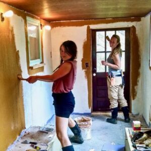 apprentices applying earthen paint to walls