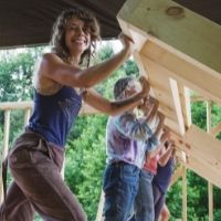 women raising a wall in a tiny house