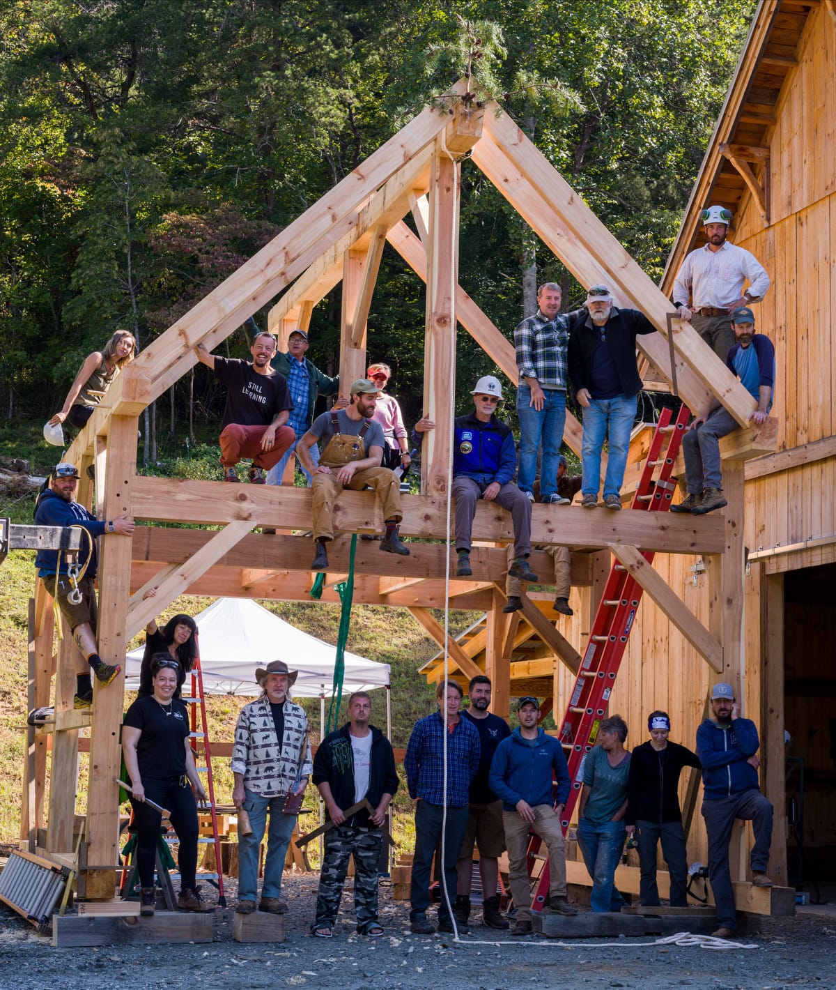 smiling students pose for a class picture at the end of a Timber Framing Workshop at Wild Abundance