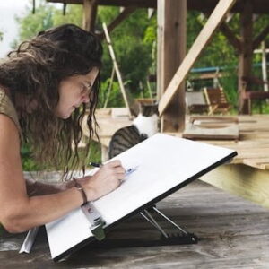 Natalie working on a drafting table designing a tiny house