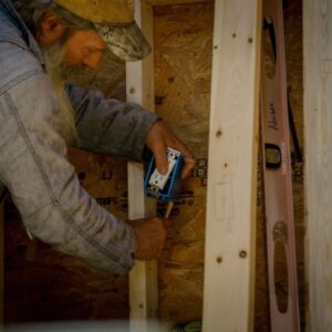 man installing an outlet in a tiny house