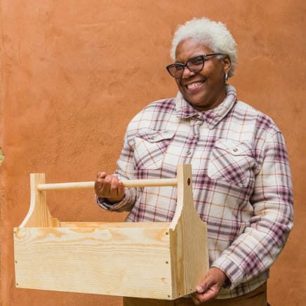 A student shows off her solo project at the end of a women's carpentry class, a 4 day workshop at Wild Abundance DIY skills school.