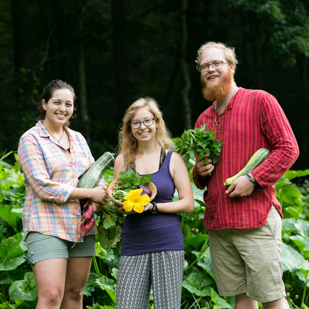 Students holding vegetables they harvested in the Gardening and Permaculture Apprenticeship 9 month program at Wild Abundance