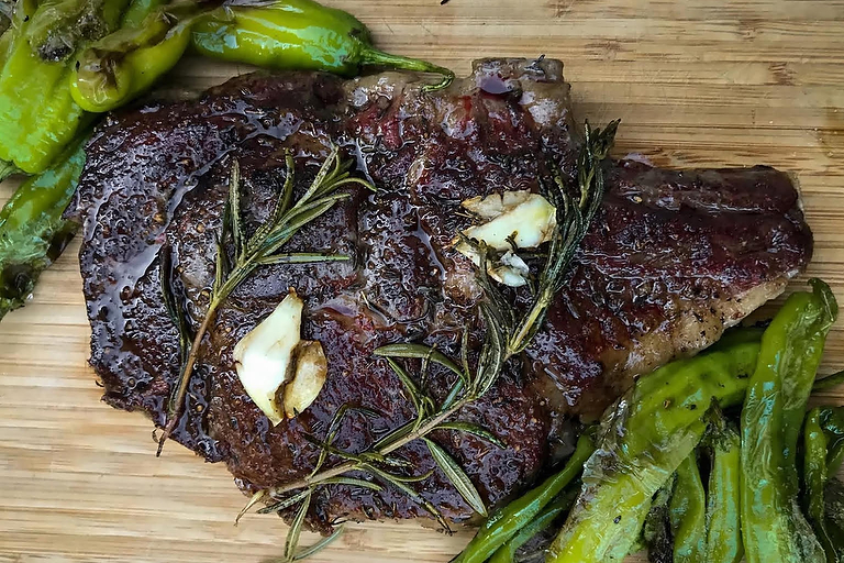 A cut of meat is prepared with foraged herbs in a healthy women's cooking and Nourishing Foods retreat at Wild Abundance